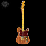 Electric guitar with a wooden body and neck on a black background, featuring the Tone Shop logo.