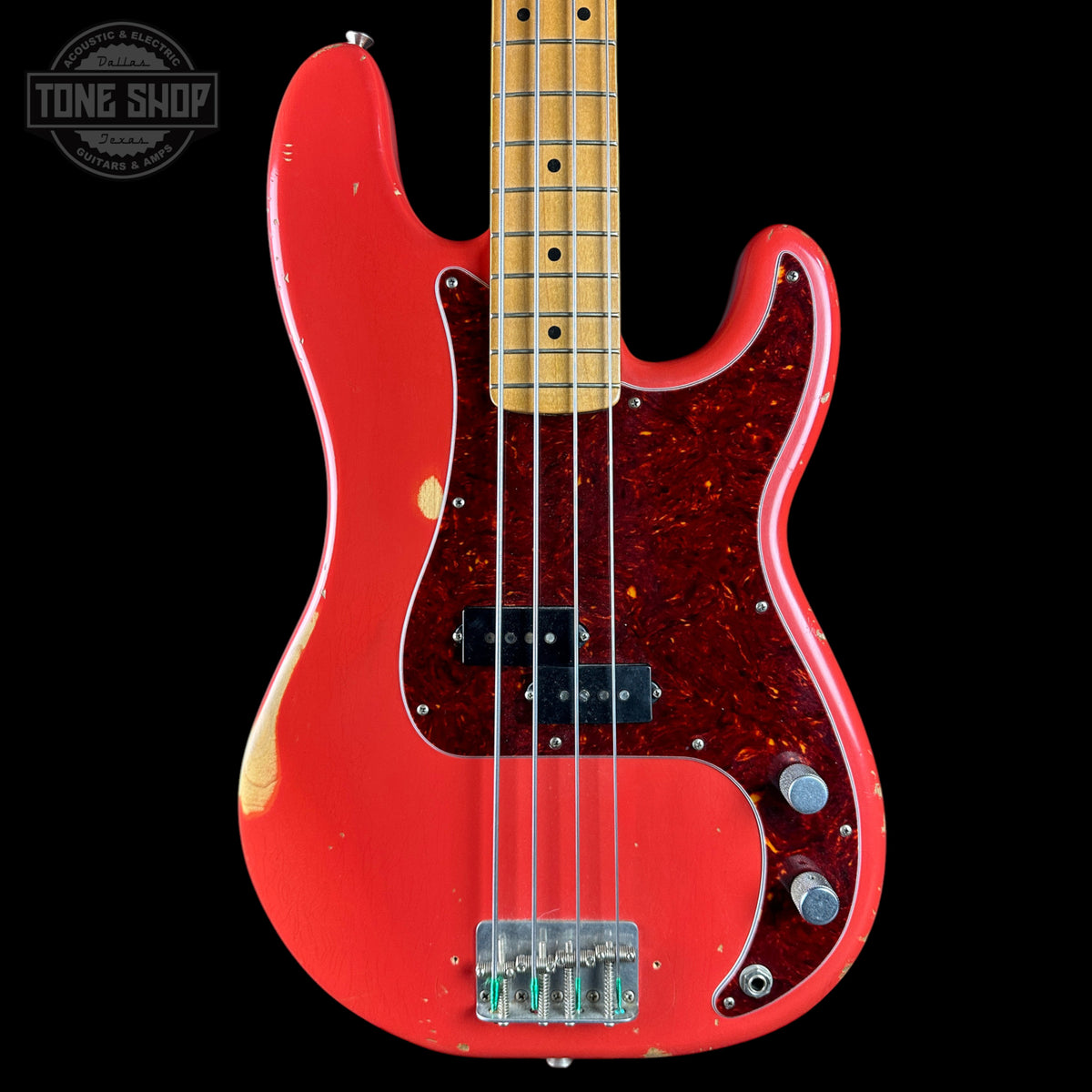 Red electric bass guitar with a black background, featuring the Tone Shop logo.