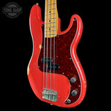 Red electric bass guitar with a black background, featuring the Tone Shop logo.