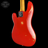 Red electric guitar body with a visible brand logo on a black background