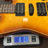 Used Schecter Diamond Series on scale displaying weight.