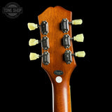 Guitar headstock with tuning pegs on a black background, featuring 'Tone Shop' branding.