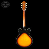 Electric guitar with sunburst finish on a black background, featuring the Tone Shop logo.