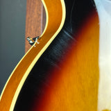 Close-up of a wooden acoustic guitar with a dark brown finish.