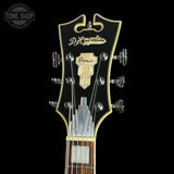 Guitar headstock with D'Angelico logo on a black background