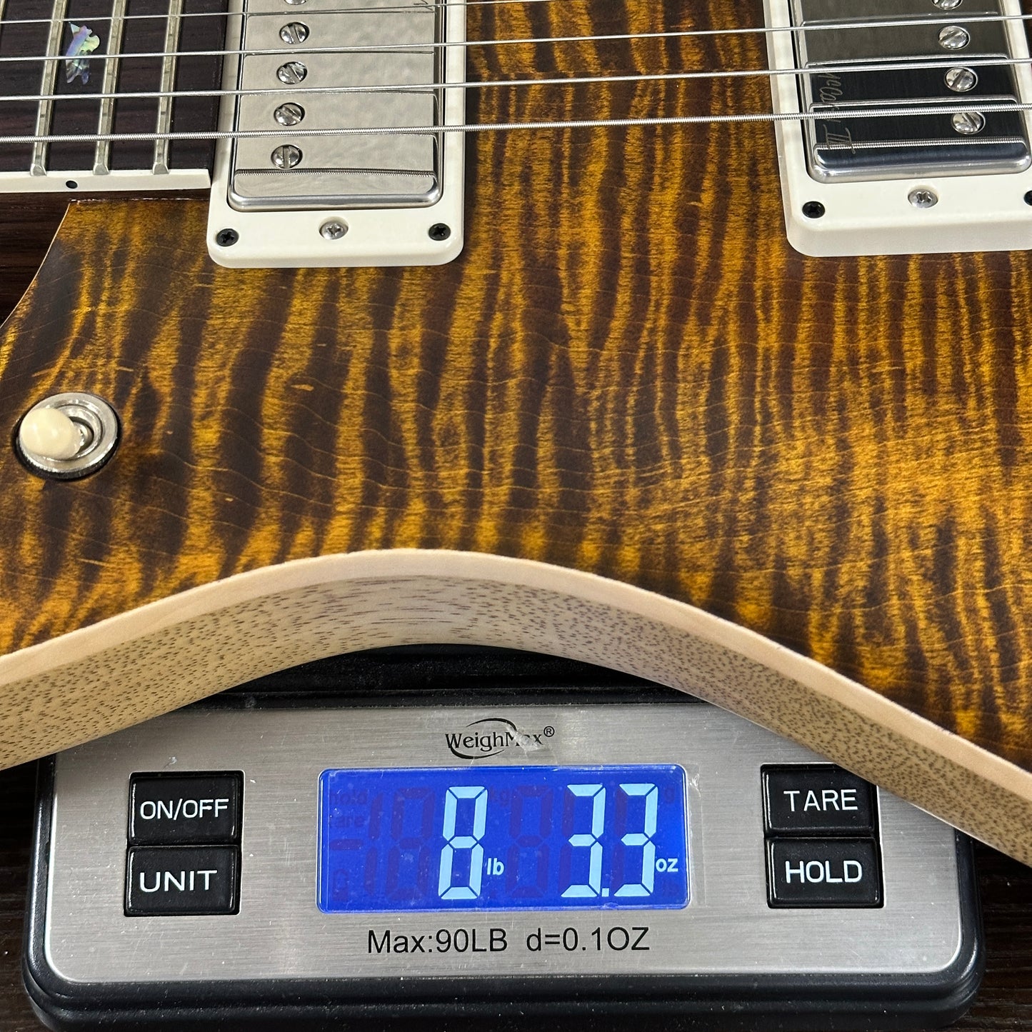 Guitar on a digital scale displaying weight
