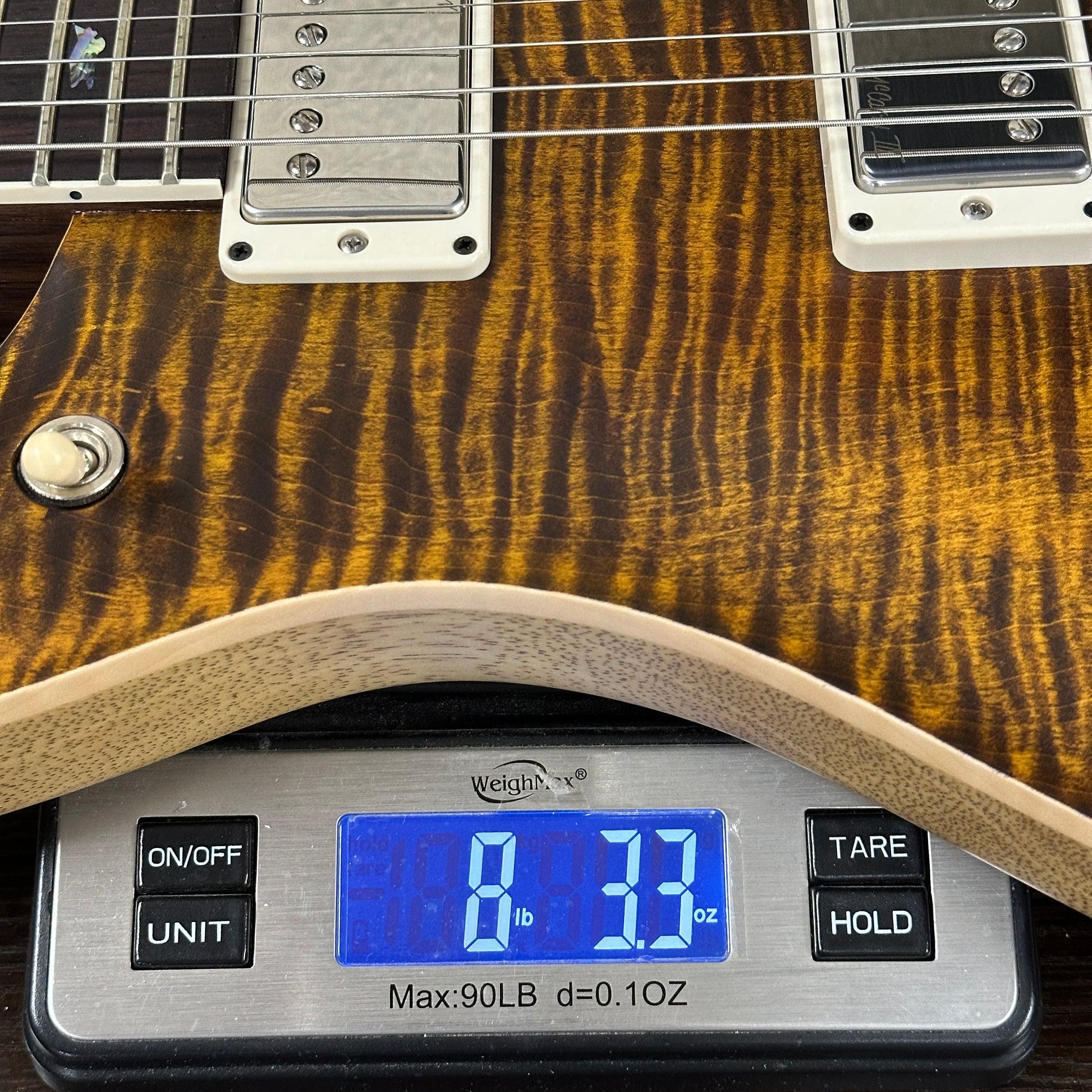Guitar on a digital scale displaying weight