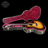 Acoustic guitar in a hard-shell case with 'Tone Shop' logo.