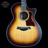 Acoustic guitar with a sunburst finish on a black background, featuring the Tone Shop logo.