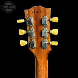 Close-up of the headstock of an acoustic guitar against a black background, showing six yellow tuning pegs, metal tuning machines, and the serial number 961822 printed on the back. A Tone Shop watermark is visible in the top left corner.
