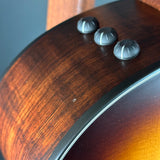 Close-up of a guitar's wood finish with control knobs.