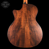 Close-up of a wooden guitar body with 'Tone Shop' logo in the corner.