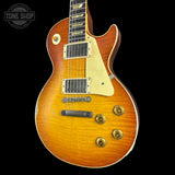 A classic electric guitar with a sunburst finish, featuring a cream pickguard, gold-toned hardware, and a dark fretboard, shown against a solid black background.