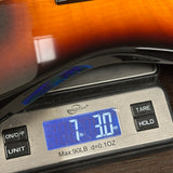 Used Jackson Electric Sunburst on scale displaying weight.