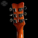 Guitar headstock with tuning pegs on a black background, featuring the Tone Shop logo.