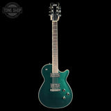 Electric guitar with a teal finish on a black background, featuring the Tone Shop logo.