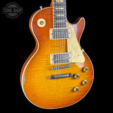 A classic electric guitar with a sunburst finish, featuring a cream pickguard, gold hardware, and a dark fretboard, shown against a solid black background.