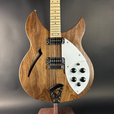 Wooden electric guitar with a white pickguard on a gray background