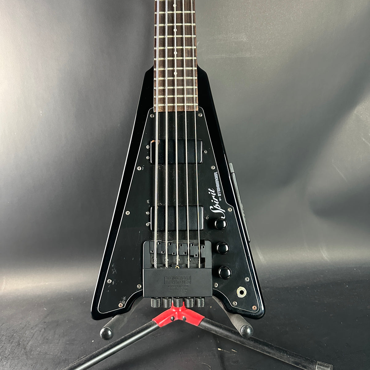 Black electric guitar on a gray background