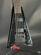 Close-up of a black electric guitar with visible brand name on a dark background