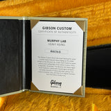 A Gibson Custom Certificate of Authenticity card for a Murphy Lab heavy-aging Gibson guitar instrument, displayed inside an open light wood presentation folder on a textured golden-yellow background.
