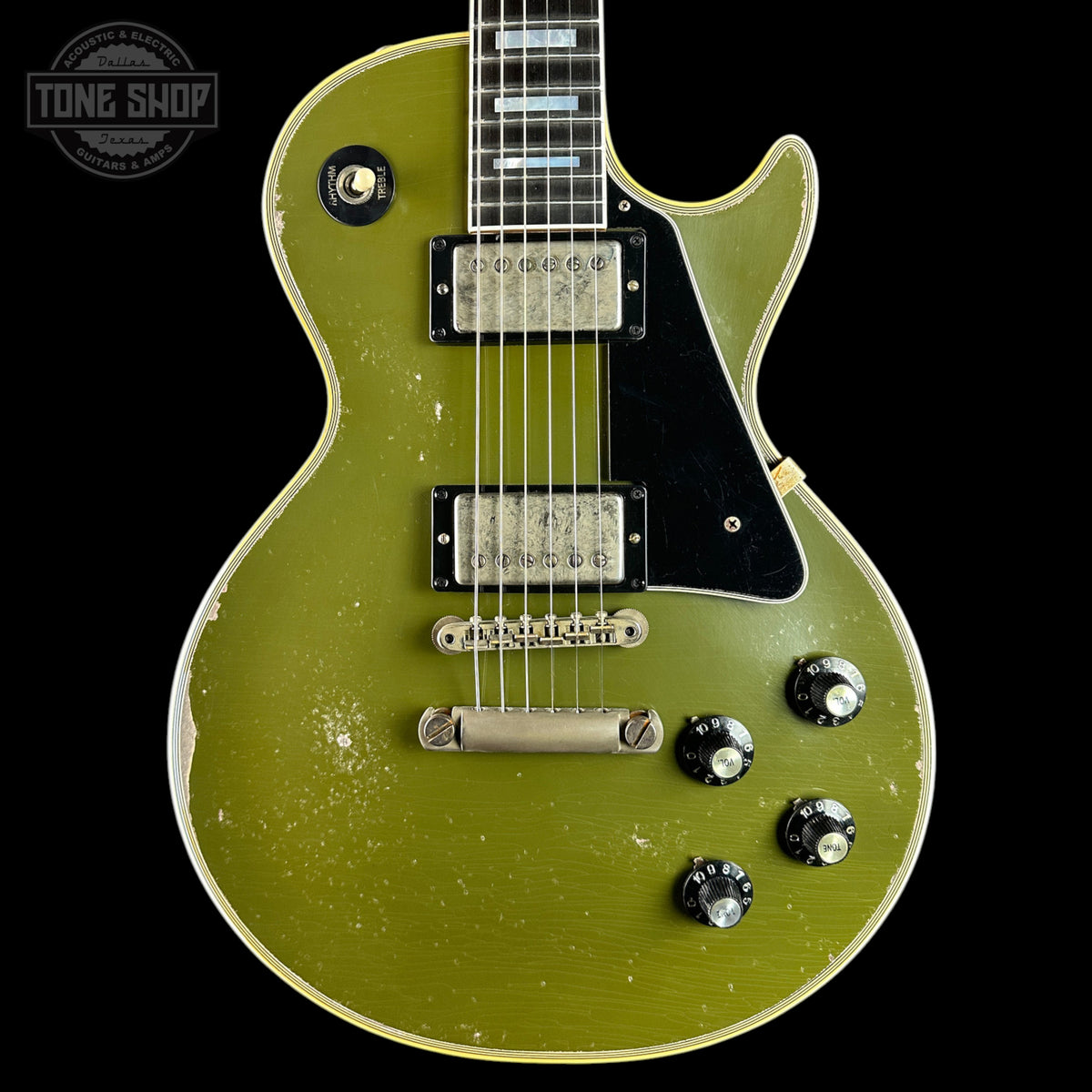 A Gibson Les Paul Custom electric guitar in a distressed olive green finish, featuring a black pickguard, chrome hardware, and a worn vintage patina on a black background.