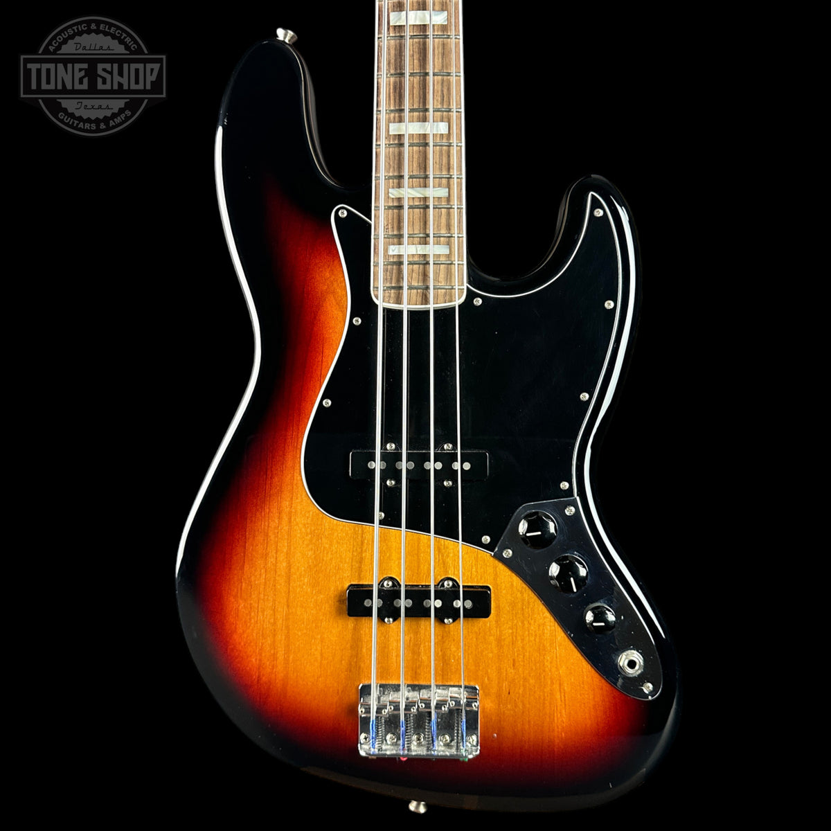 Electric bass guitar with a sunburst finish on a black background, featuring the Tone Shop logo.