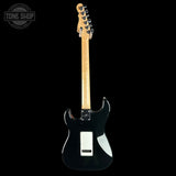 A black electric guitar with a natural wood neck and headstock, photographed from the back against a solid black background. A 'TONE SHOP' watermark is visible in the top-left corner.