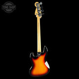 Electric bass guitar with sunburst finish on a black background, featuring the Tone Shop logo.