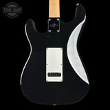 The back of a black electric guitar with a maple neck, white pickguard, and a white curved accent on the body, shown against a black background with a Tone Shop watermark.