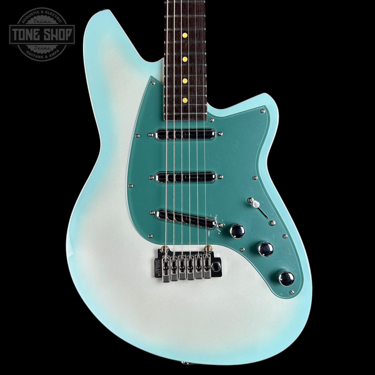 A double-cutaway electric guitar with a light blue to white gradient body, a teal pickguard, and a dark fretboard, shown against a solid black background. A Tone Shop watermark is visible in the top-left corner.