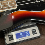 Bass guitar on a digital scale displaying weight