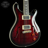 Electric guitar with a glossy finish on a black background, featuring the Tone Shop logo.