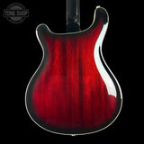 Red electric guitar body on a black background with 'Tone Shop' logo.