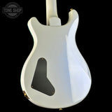 White electric guitar with a black pickguard on a black background, featuring 'Tone Shop' branding.