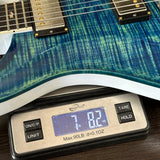 Blue electric guitar on a digital scale displaying weight.