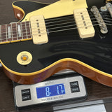 Electric guitar on a digital scale displaying weight