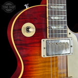 Close-up of a red electric guitar with a visible brand logo in the corner.