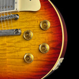 Close-up of a sunburst electric guitar with gold hardware on a black background