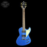 Blue electric guitar with a white pickguard on a black background, featuring the Tone Shop logo.