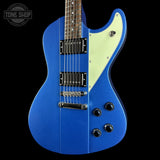 Blue electric guitar with a white pickguard on a black background, featuring the Tone Shop logo.