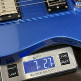 Blue electric guitar being weighed on a digital scale