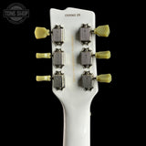 Close-up of a guitar headstock with tuning pegs on a white background, featuring the Tone Shop logo.