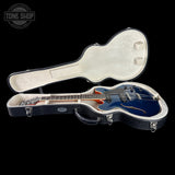 Blue electric guitar in a black case with 'Tone Shop' logo.