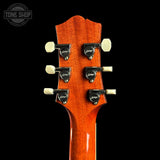 Guitar headstock with tuning pegs on a black background, featuring the Tone Shop logo.
