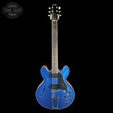 Blue electric guitar on a black background with 'Tone Shop' logo.