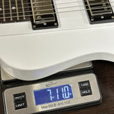 Digital scale displaying weight of a white electric guitar