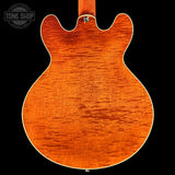 Close-up of a wooden guitar body with 'Tone Shop' logo in the corner.