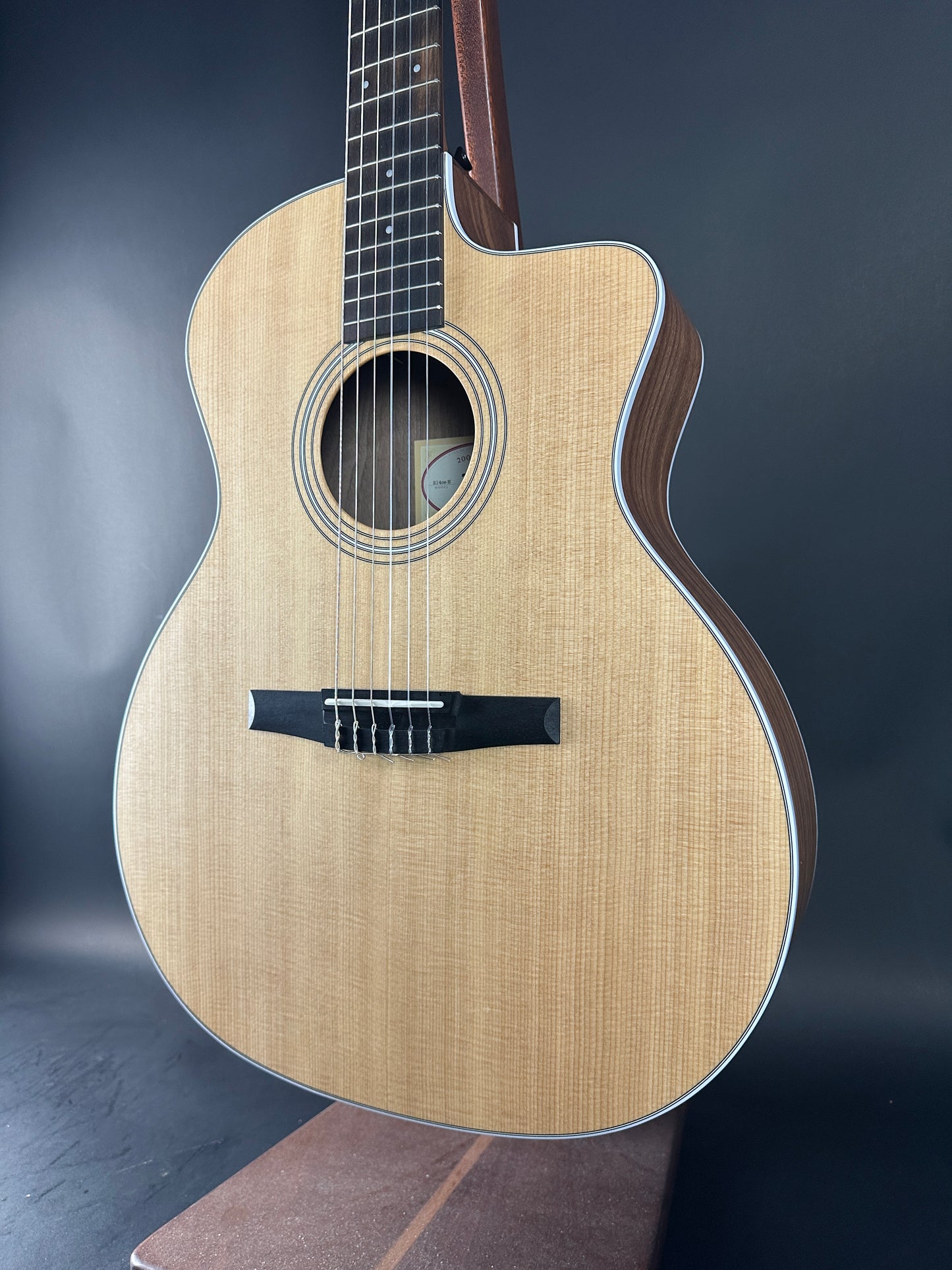 Acoustic guitar with a dark brown finish on a gray background