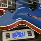 Blue electric guitar on a digital scale displaying weight